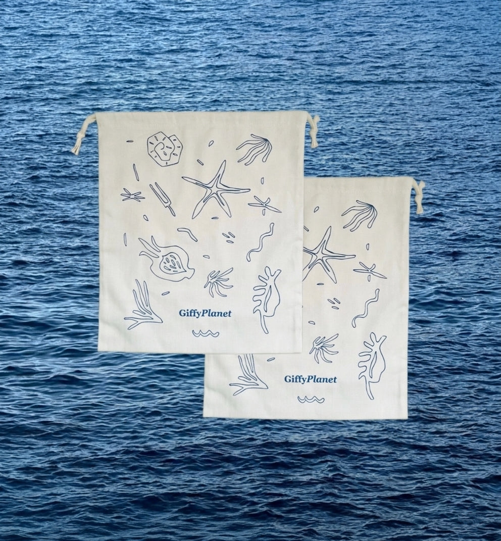 Two white drawstring bags with ocean-themed designs on a blue water background